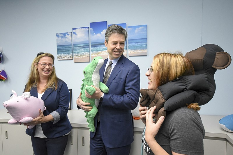 Chattanooga Mayor Andy Berke enjoys a moment with in the  SensaCalm showroom with founder/CEO Donna Chambers, left, and general manager Sarah Messimer. The three held stuffed animals they produced called Peaceful Pals.