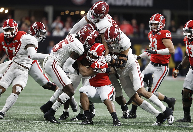 Alabama redshirt sophomore defensive lineman Quinnen Williams (92) jumps on a pile of Crimson Tide defenders in an effort to stop Georgia tailback Nick Chubb during January's national championship game in Atlanta.