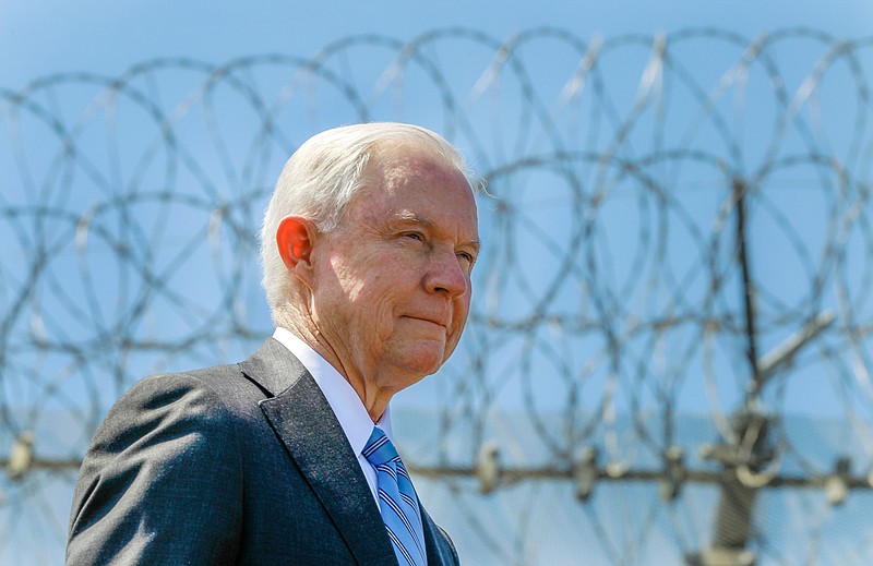 In this Friday, April 21, 2017, file photo, United States Attorney General Jeff Sessions stands near a secondary border fence during a news conference at the U.S.-Mexican border next to the Brown Field Border Patrol Station in San Diego. Sessions is scheduled to speak about immigration to a meeting of sheriffs, Wednesday, April 11, 2018, in Las Cruces, N.M. (Hayne Palmour IV/The San Diego Union-Tribune via AP, File)