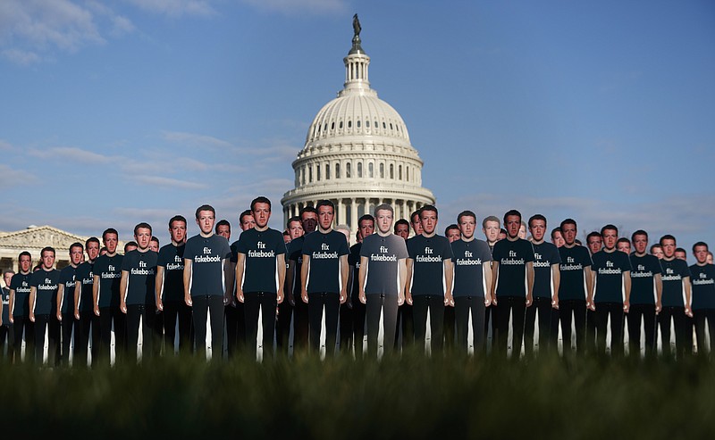 Life-sized cutouts depicting Facebook CEO Mark Zuckerberg wearing "Fix Fakebook" T-shirts are displayed by advocacy group, Avaaz, on the South East Lawn of the Capitol on Tuesday ahead of Zuckerberg's appearance before a Senate Judiciary and Commerce Committees joint hearing. (AP Photo/Carolyn Kaster)