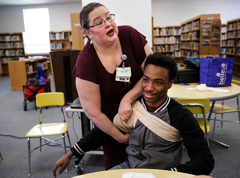 Nurse Regena Young demonstrates packing and wrapping an armpit wound with student LaTrel Menifee during a "Stop the Bleed" class at Brainerd High School on Wednesday, April 11, 2018, in Chattanooga, Tenn. Erlanger Hospital provided first aid training focused on slowing blood loss in trauma victims for the health occupations classes and interested faculty and students at Brainerd.