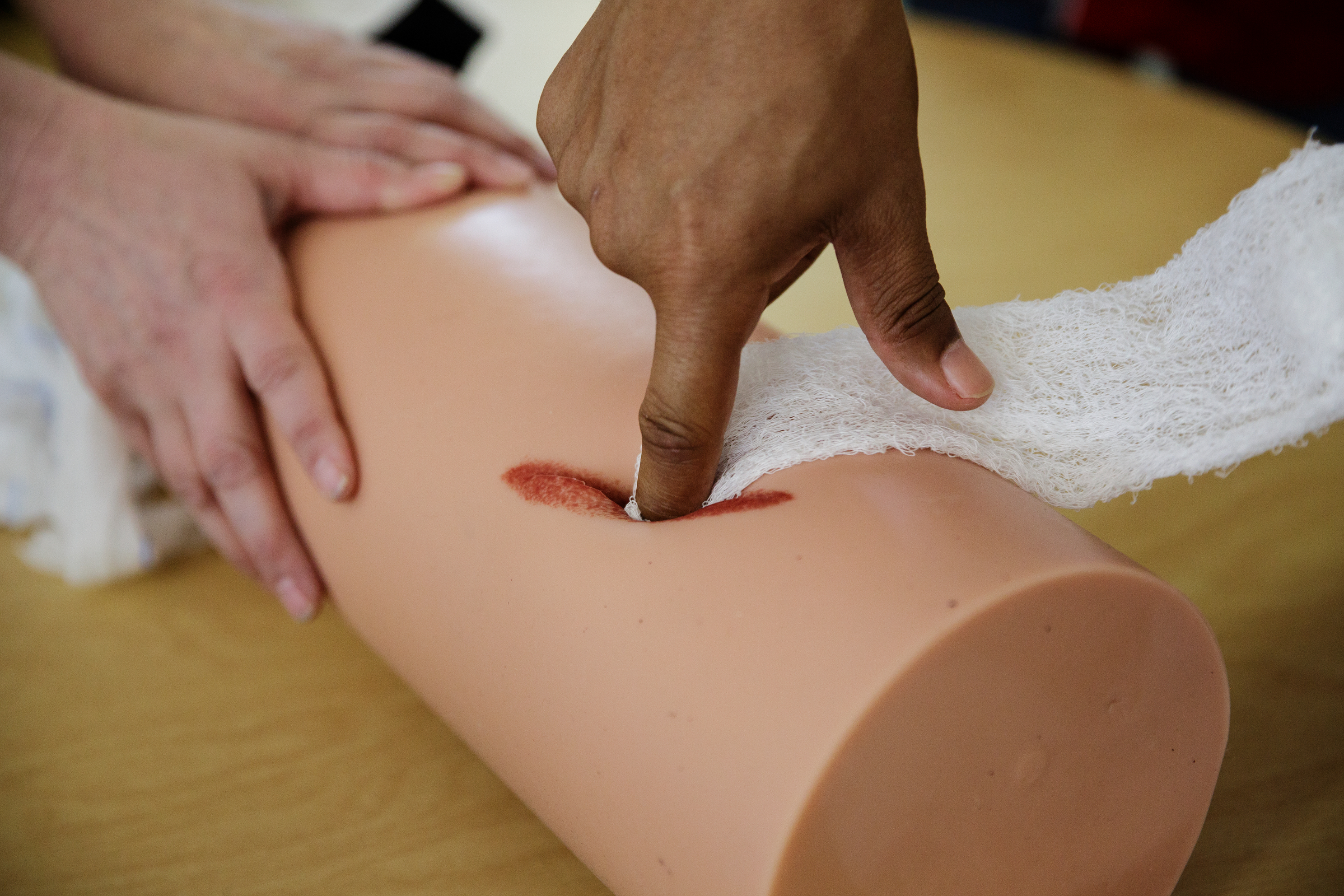 Brainerd basketball coach Levar Brown practices packing a wound with gauze on a practice foam device during a "Stop the Bleed" class at Brainerd High School on Wednesday, April 11, 2018, in Chattanooga, Tenn. Erlanger Hospital provided first aid training focused on slowing blood loss in trauma victims for the health occupations classes and interested faculty and students at Brainerd.