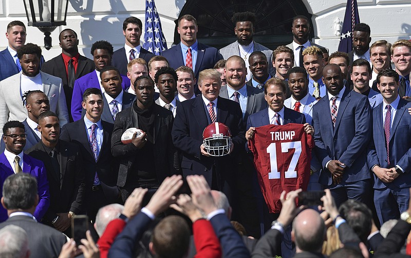 President Donald Trump, center, poses for a photos with the 2017 NCAA National Champion University of Alabama football team at the White House in Washington, Tuesday, April 10, 2018. Head coach Nick Saban told the Trump jersey. (AP Photo/Susan Walsh)