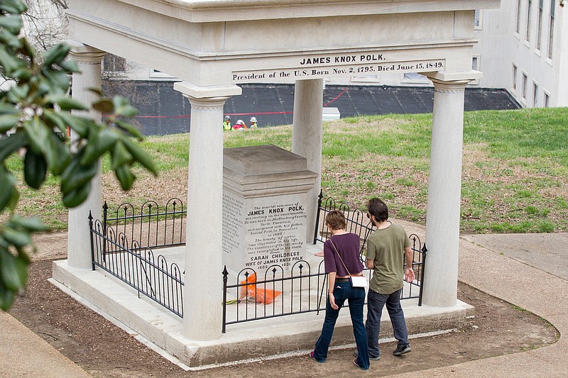 FILE - In a March 24, 2017 file photo, visitors look at the burial place of President James K. Polk and his wife, Sarah Polk, on the grounds of the state Capitol in Nashville, Tenn. The body of former president James K. Polk has been moved three times since he died of cholera in 1849, and now an effort to move it again has taken on a life of its own in the Tennessee Legislature. A much-debated resolution urging that his remains be moved to a fourth resting place appeared dead in March 2018, but was resurrected before winning final approval Monday night, April 9, 2018, in the House. (AP Photo/Erik Schelzig, File)

