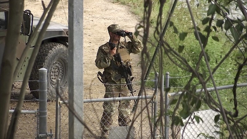 In this April 10, 2018, frame from video, a National Guard troop watches over Rio Grande River on the border in Roma, Texas. The deployment of National Guard members to the U.S.-Mexico border at President Donald Trump's request was underway Tuesday with a gradual ramp-up of troops under orders to help curb illegal immigration. (AP Photo/John Mone)