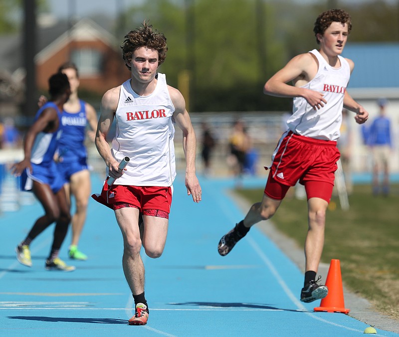 Baylor's James Post takes off with the baton after grabbing it from teammate Sam MacMillan as he runs the second leg of the 4x800 event during the Optimist Track and Field meet Friday, April 13, 2018 at Girls Preparatory School in Chattanooga, Tenn. 