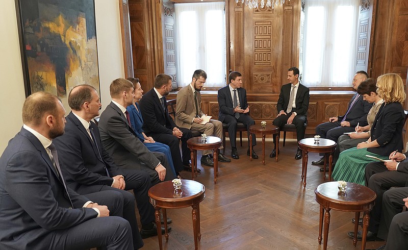 This photo released by the Syrian official news agency SANA, shows Syrian President Bashar Assad, center right, meets with Russian politicians, in Damascus, Syria, Sunday, April 15, 208. Assad says the Western airstrikes against his country were accompanied by a campaign of "lies" and misinformation in the U.N. Security Council. (SANA via AP)