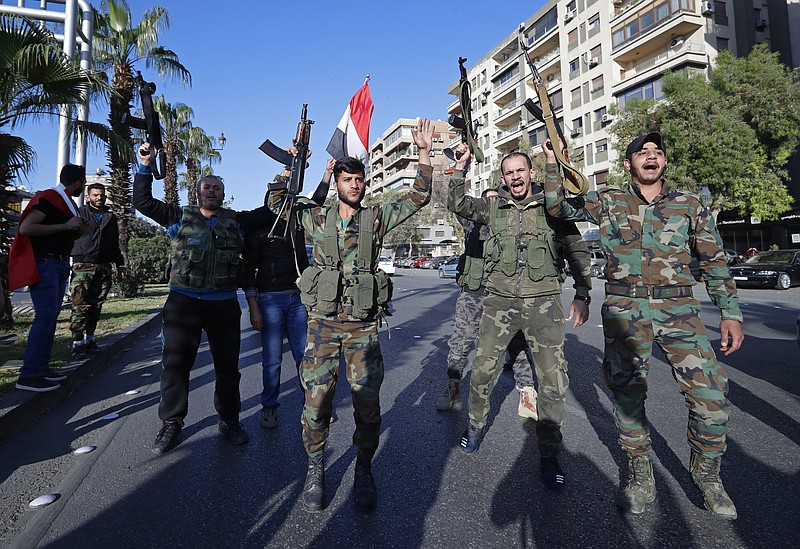 Syrian soldiers hold their weapons as they dance and chant slogans against U.S. President Trump during demonstrations following a wave of U.S., British and French military strikes to punish President Bashar Assad for suspected chemical attack against civilians, in Damascus, Syria, Saturday, April 14, 2018.