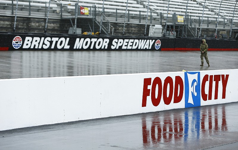 A person walks along the track in the rain before a NASCAR Cup Series auto race, Sunday, April 15, 2018, in Bristol, Tenn. (AP Photo/Wade Payne)
