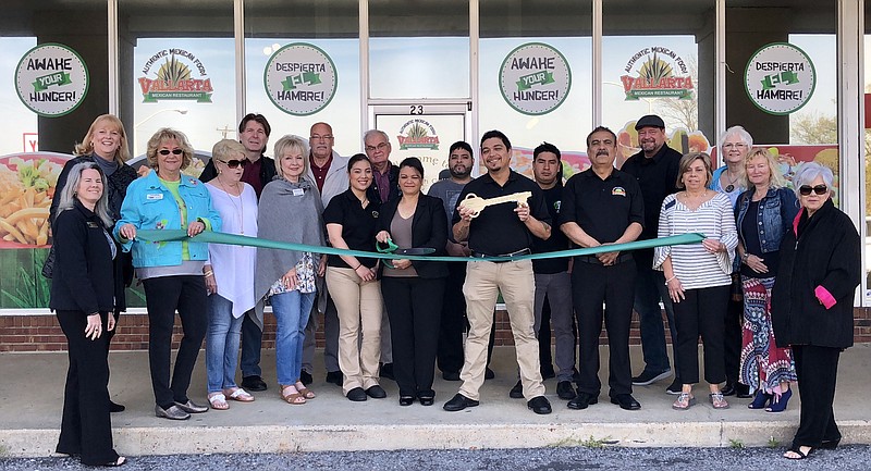 Vallarta Mexican Restaurant owner Maria Gaytan clutches a pair of scissors and restaurant manager Martin Dominguez holds up a ceremonial key during a ribbon-cutting for the establishment April 11. Restaurant staff and representatives from the Catoosa County Chamber of Commerce surround them to mark the occasion. (Contributed photo by Catoosa County Chamber)