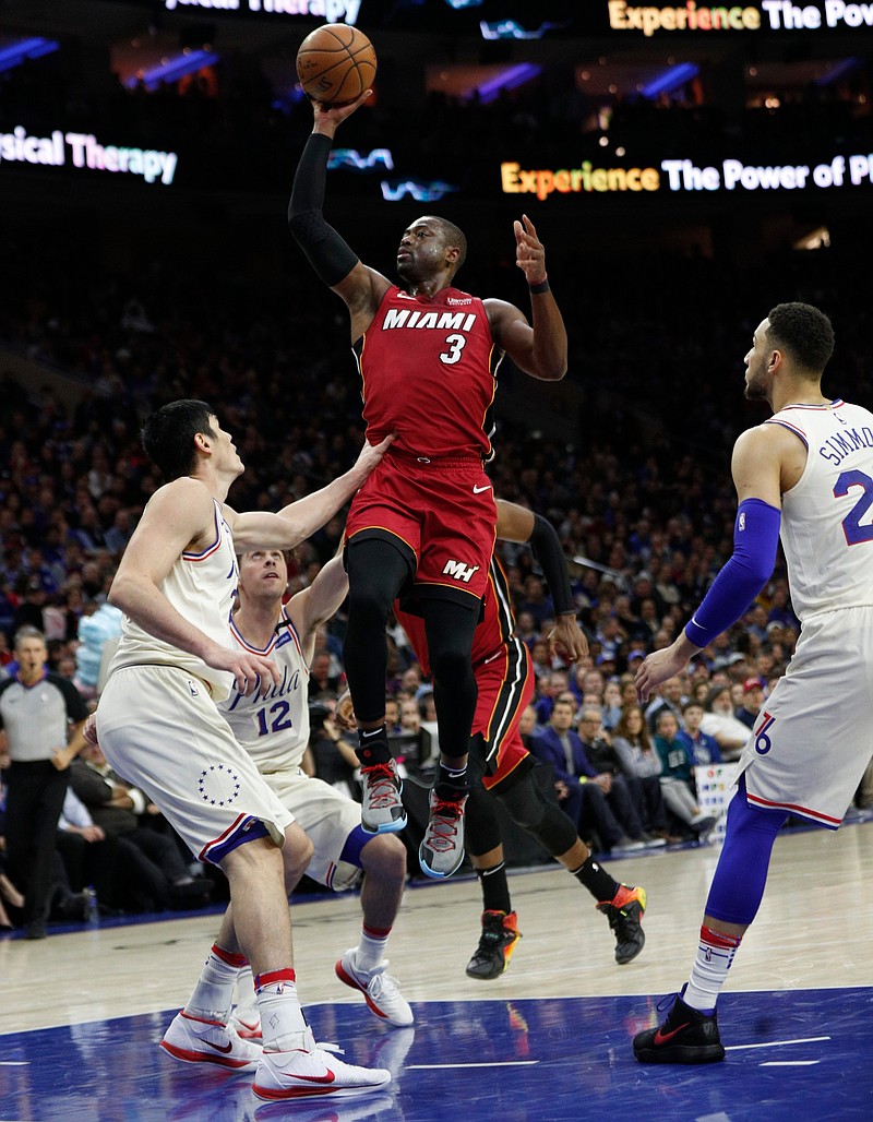 Miami Heat's Dwyane Wade, right, shoots with Philadelphia 76ers' T.J. McConnell, center, and Ersan Ilyasova, left, of Turkey, defend during the first half in Game 2 of a first-round NBA basketball playoff series, Monday, April 16, 2018, in Philadelphia. (AP Photo/Chris Szagola)