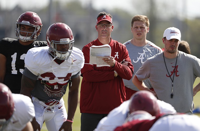 Alabama associate head coach and quarterbacks coach Dan Enos holds some play sheets and notes during a recent Crimson Tide practice.