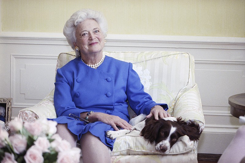 FILE - In this 1990 file photo, first lady Barbara Bush poses with her dog Millie in Washington. A family spokesman said Tuesday, April 17, 2018, that former first lady Barbara Bush has died at the age of 92. (AP Photo/Doug Mills, File)