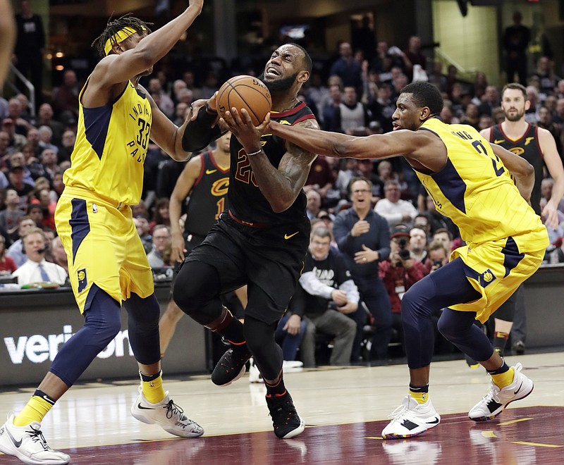 Cleveland Cavaliers' LeBron James, center, drives between Indiana Pacers' Myles Turner, left, and Thaddeus Young during the first half of Game 2 of an NBA basketball first-round playoff series Wednesday, April 18, 2018, in Cleveland. (AP Photo/Tony Dejak)