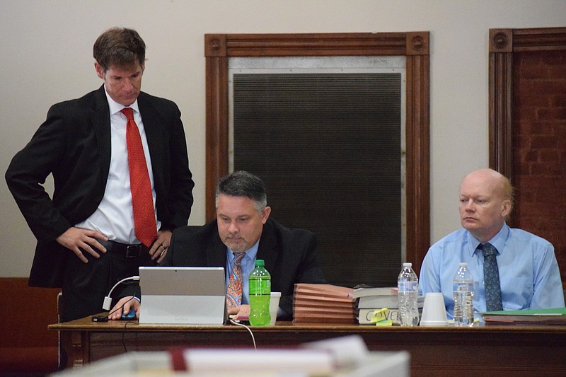 Douglas Alvey, right, watches as his attorneys, Clancy Covert, seated, and Lee Ortwein review notes during a break in the trial on Wednesday in Rhea County Circuit Criminal Court.