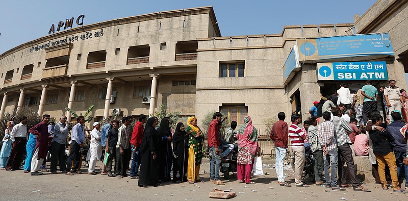 FILE- In this Dec. 2, 2016, file photo, Indians stand in a queue outside a bank to withdraw cash in Ahmadabad, India. Roughly seven out of every 10 adults worldwide now has some form of a bank account, the World Bank said Thursday, April 19, 2018, fueled largely by the proliferation of cell phone-based bank accounts and other simple bank account programs in places like India and Sub-Saharan Africa. (AP Photo/Ajit Solanki, File)