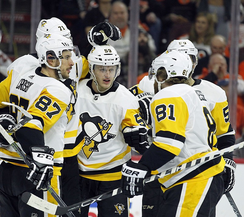 Pittsburgh Penguins' Sidney Crosby, Evgeni Malkin (71), Jake Guentzel, Kris Letang and Phil Kessel, from left, celebrate Malkin's goal during the first period in Game 4 of an NHL first-round hockey playoff series against the Philadelphia Flyers, Wednesday, April 18, 2018, in Philadelphia. The Penguins won 5-0. (AP Photo/Tom Mihalek)