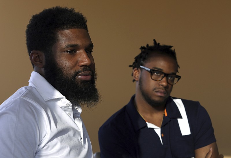 In this Wednesday, April 18, 2018 photo, Rashon Nelson, left, and Donte Robinson, right, listen to a reporter's question during an interview with The Associated Press in Philadelphia. 