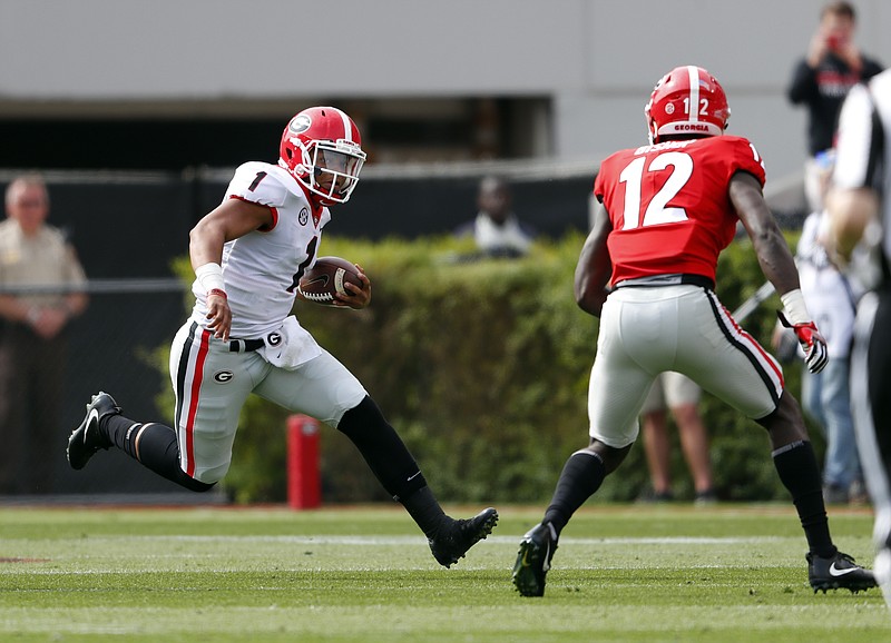 Georgia quarterback Justin Fields tries to run past Tray Bishop during the first half of the Bulldogs' G-Day spring scrimmage on Saturday in Athens, Ga.