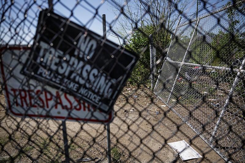 No trespassing signs are seen on the fence surrounding the former site of a homeless encampment on city-owned property behind the municipal wellness center on East 11th Street on Thursday, April 12, 2018, in Chattanooga, Tenn. The camp's residents were removed from the site because the property is a toxic brownfield. Out of 130 residents counted in the camp, 80 have applied for housing through Chattanooga Housing Authority and 8 have been approved, according to Twitter posts by Mayor Andy Berke's deputy chief of staff Kerry Hayes.