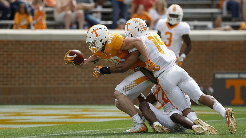 Tennessee tight end Eli Wolf, with ball, stretches toward the end zone as defensive back Micah Abernathy, bottom, and linebacker Quart'e Sapp try to stop him during the Orange and White spring game on April 21 at Neyland Stadium.