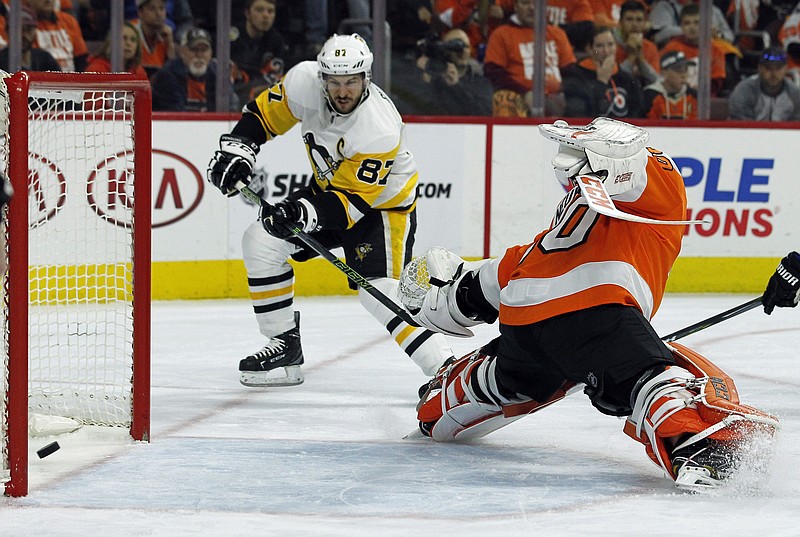 
              Pittsburgh Penguins' Sidney Crosby, left, scores past Philadelphia Flyers' Michal Neuvirth during the first period in Game 6 of an NHL first-round hockey playoff series Sunday, April 22, 2018, in Philadelphia. (AP Photo/Tom Mihalek)
            