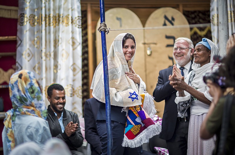 
              Israel's Justice Minister Ayelet Shaked receives traditional clothes from members of Ethiopia's Jewish community, during a visit to a synagogue in Addis Ababa, Ethiopia Sunday, April 22, 2018. Shaked visited the synagogue in a rare visit from the high office of Israel's government and her first trip to Africa. (AP Photo/Mulugeta Ayene)
            