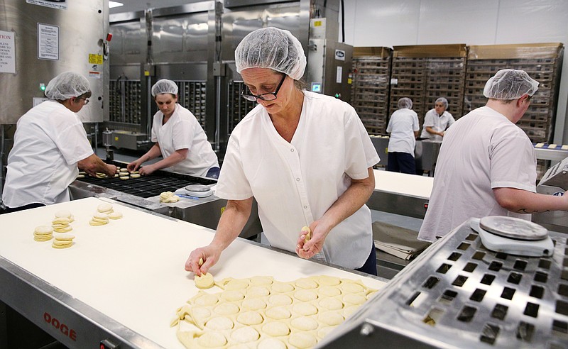 Amanda Beaver separates scrap from the shells of doughnuts that will be filled with jellies Tuesday, April 17, 2018 at BMG Bakery in Ringgold, Ga. Each day, BMG Bakery produces approximately 480,000 doughnuts for 46 Dunkin' Donuts locations in nearby markets such as Knoxville, Atlanta, Chattanooga, Fort Oglethorpe and Murfreesboro, among others.