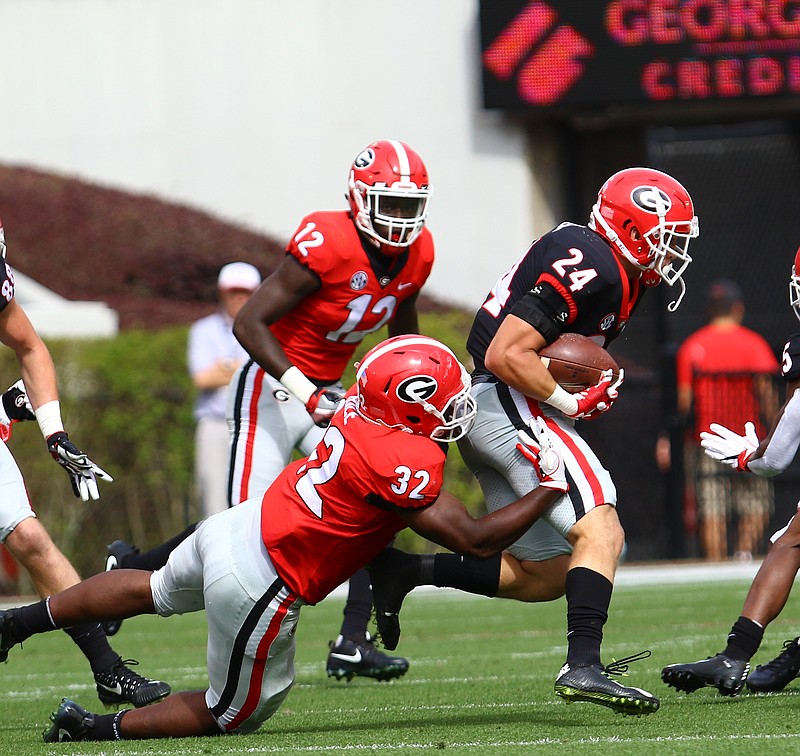 Georgia sophomore inside linebacker Monty Rice (32) makes one of his 14 G-Day tackles Saturday afternoon at the expense of walk-on tailback Prather Hudson (24).