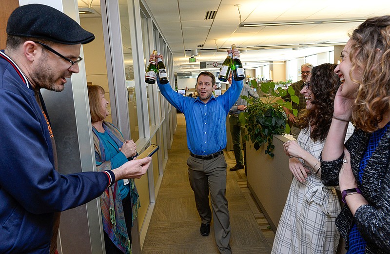 In this April 10, 2017, file photo, the Salt Lake Tribune Editor Matt Canham breaks out the champagne after their 2017 Pulitzer Prize for local reporting was announced, in Salt Like City. The Tribune newsroom takes up one floor of the building that bears its name, overlooking snow-capped mountains and the arena where the Utah Jazz play. Once a Digital First property that dealt with staff reductions and feared closure, the paper was sold to a prominent local family in 2016. Since then, its reporters received their first raise in a decade and won a Pulitzer prize for investigative reporting. (Francisco Kjolseth/The Salt Lake Tribune via AP, File)