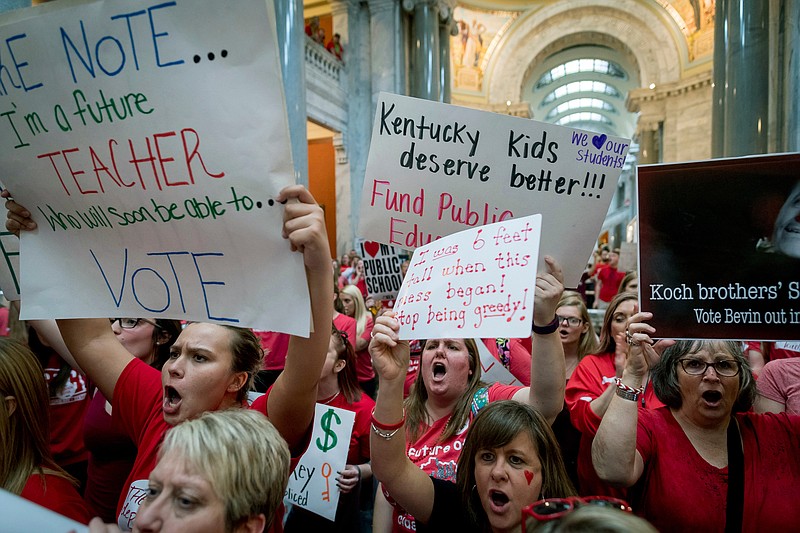 FILE - In this Friday, April 13, 2018 file photo, teachers from across Kentucky gather inside the state Capitol in Frankfort, Ky., during a rally for increased education funding.  Americans overwhelmingly believe teachers don't make enough money, and half say they'd support paying higher taxes to give educators a raise. That's according to a new poll from The Associated Press-NORC Center for Public Affairs Research that comes amid recent teacher strikes over low pay and the amount of money allocated to public schools in several Republican-led states. The poll found that parents and those without children are about as likely to think teachers are paid too little.   (AP Photo/Bryan Woolston)