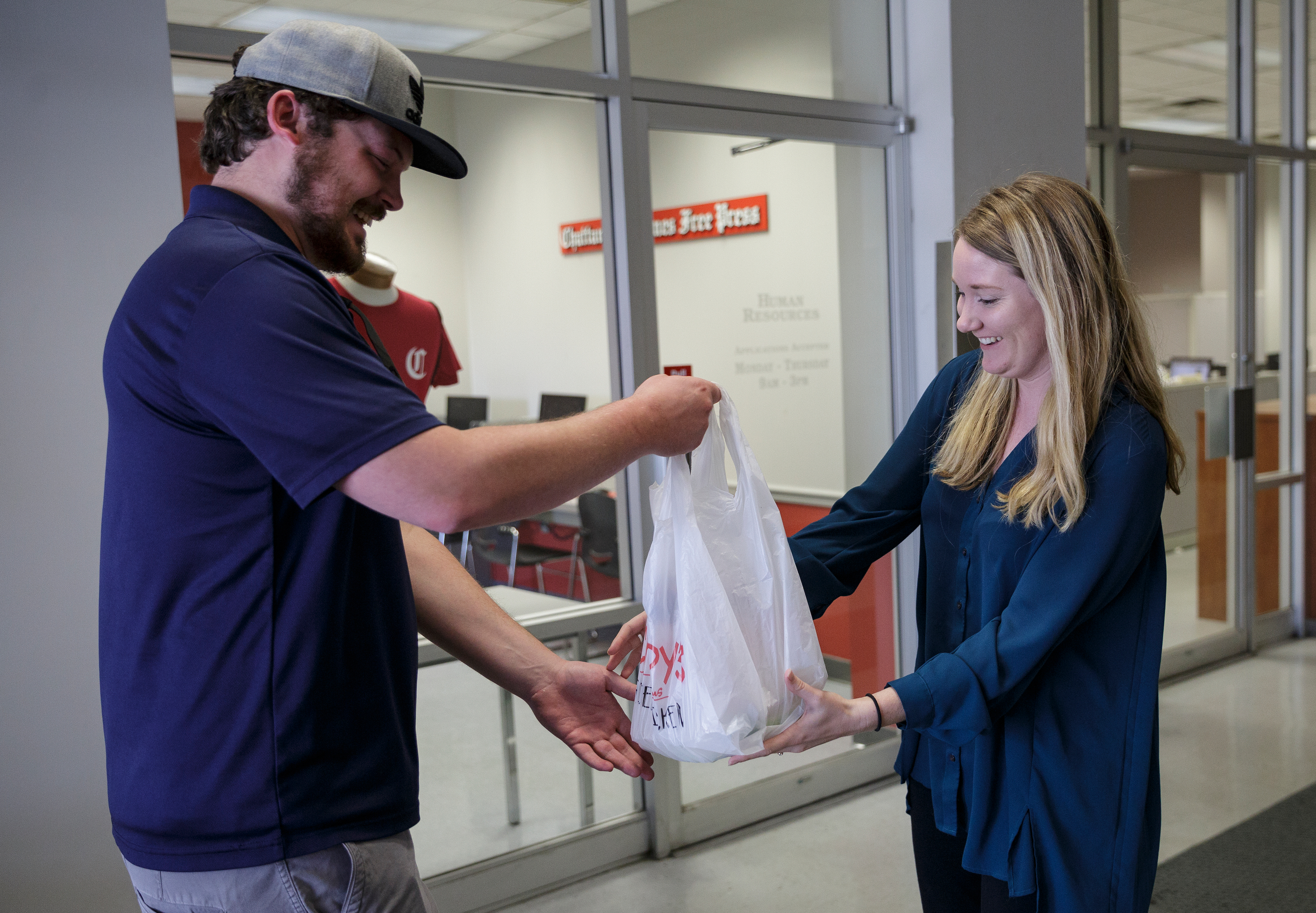 Dinner Delivered driver Cole Green hands over a Champy's salad to business reporter Allison Shirk at the Times Free Press building on Friday, April 13, 2018, in Chattanooga, Tenn.
