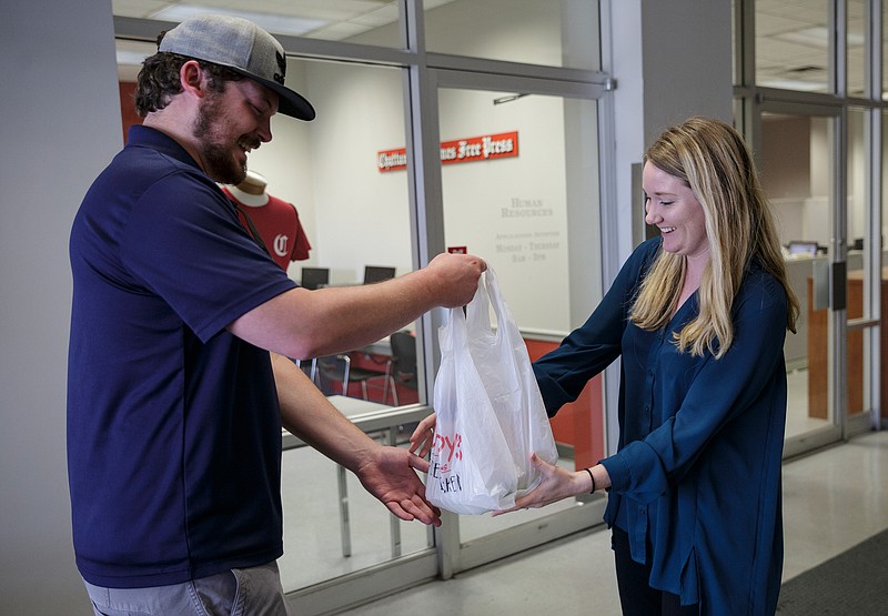 Dinner Delivered driver Cole Green hands over a Champy's salad to business reporter Allison Shirk at the Times Free Press building on Friday, April 13, 2018, in Chattanooga, Tenn. 