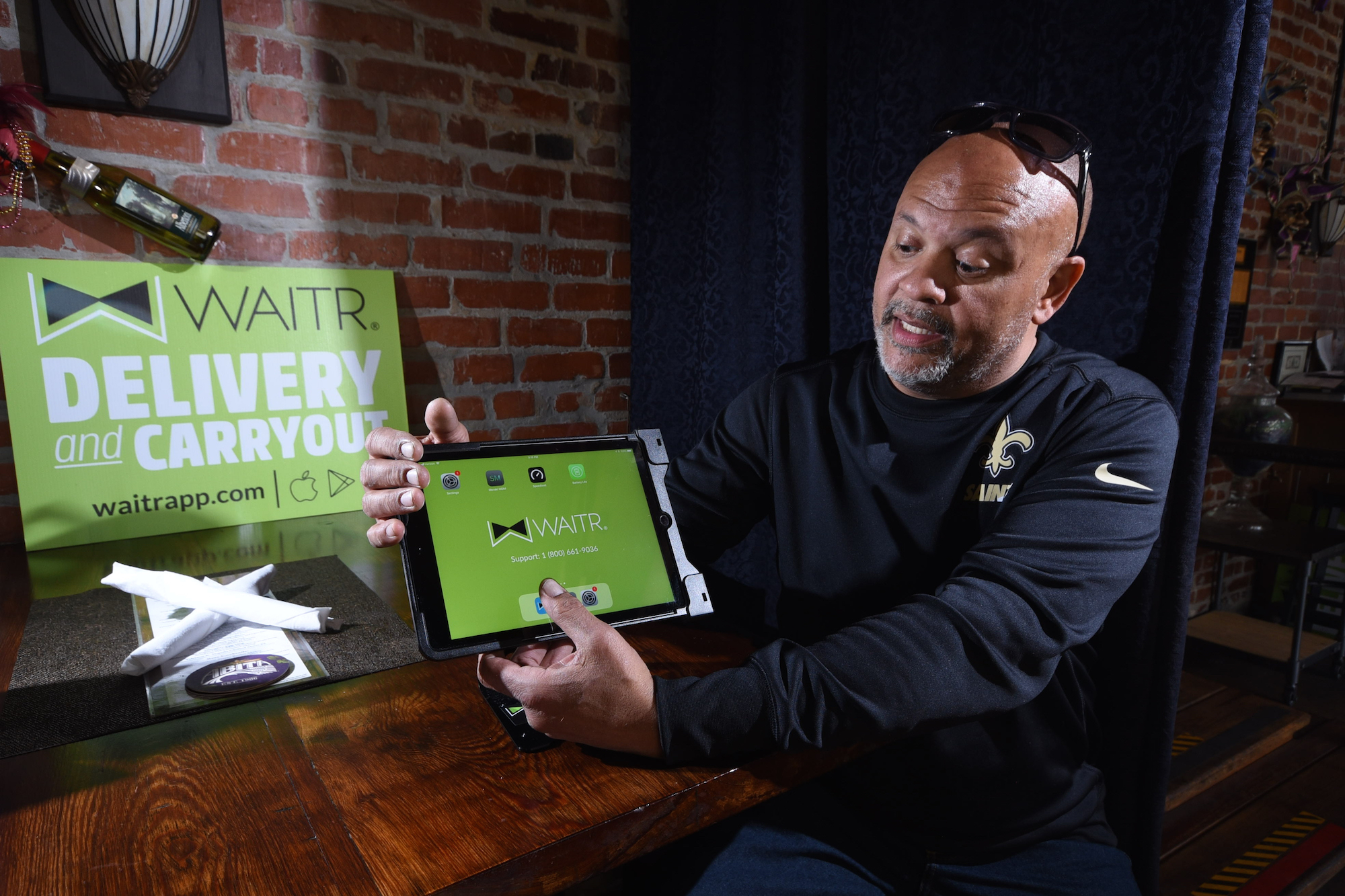 Blue Orleans chef and Mike Adams shows the iPad he uses to fill orders through the food delivery service WAITR. WAITR is one of the newest food delivery apps in town.
