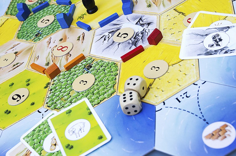 In the game The Settlers of Catan, players take the role of settlers and try to build and develop a settlement by trading resources with the other players. (PHoto: Getty Images/iStockphoto/zmeel)