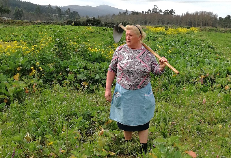 Dolores Leis stands in a field on her farm in Galicia, in northern Spain, Thursday April 19, 2018. 