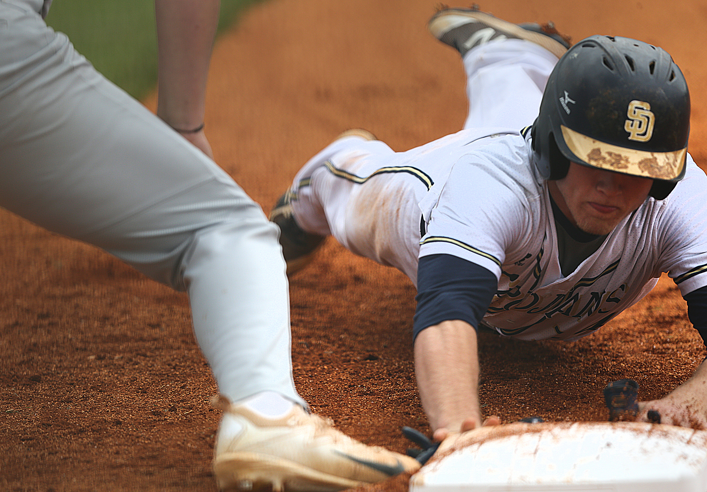Soddy-Daisy's Hayden Maynor (14) dives back into first on an attempted pickoff play during the first Soddy-Daisy vs. Bradley Central baseball game at Soddy-Daisy High School Wednesday, April 25, 2018 in Soddy-Daisy, Tenn.