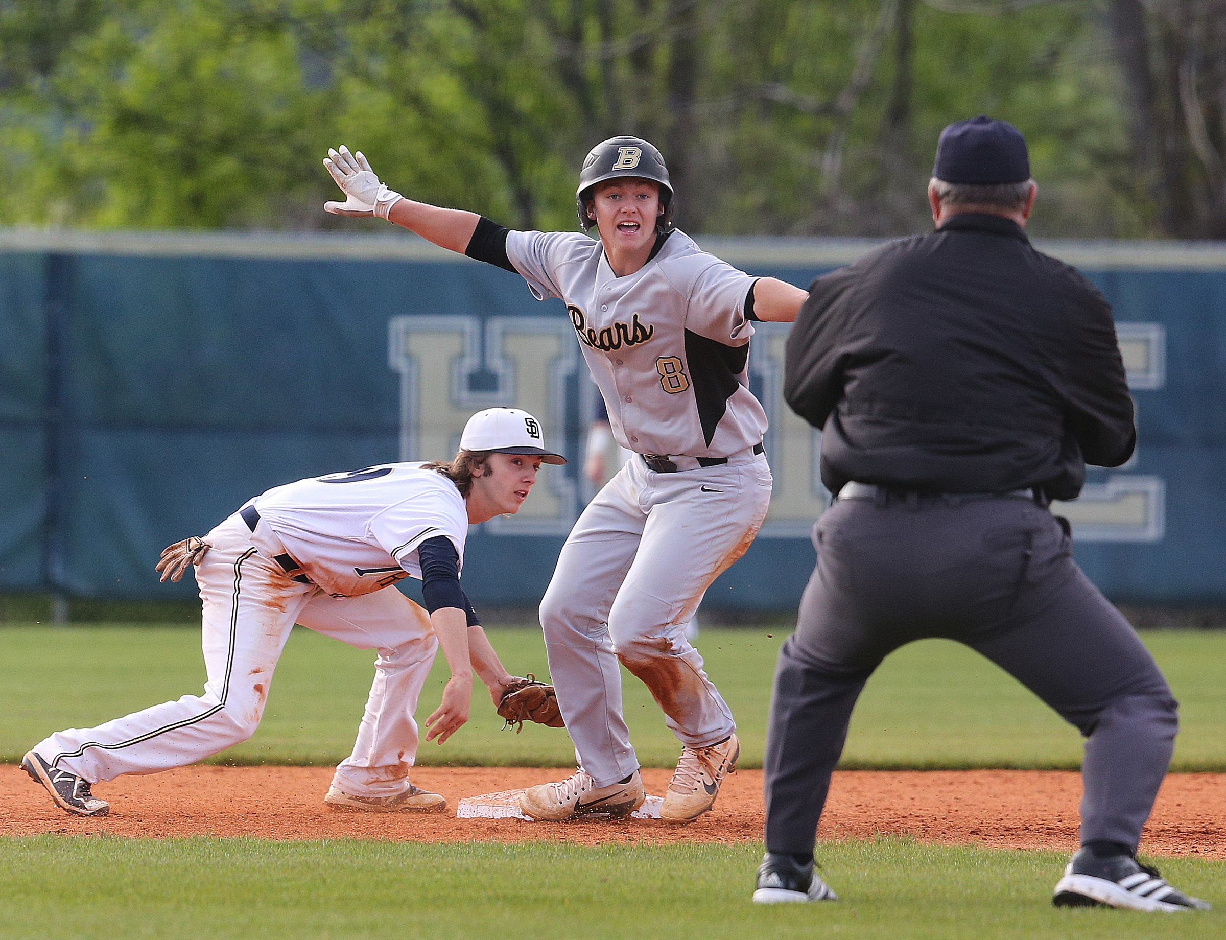 Bradley Central's Luke Ellis (8) indicates to the umpire that he believes he is safe after Soddy-Daisy's second baseman Jacob Jennings (19) briefly pulled away from the bag to reach the ball during the first Soddy-Daisy vs. Bradley Central baseball game at Soddy-Daisy High School Wednesday, April 25, 2018 in Soddy-Daisy, Tenn. The umpire called him safe.