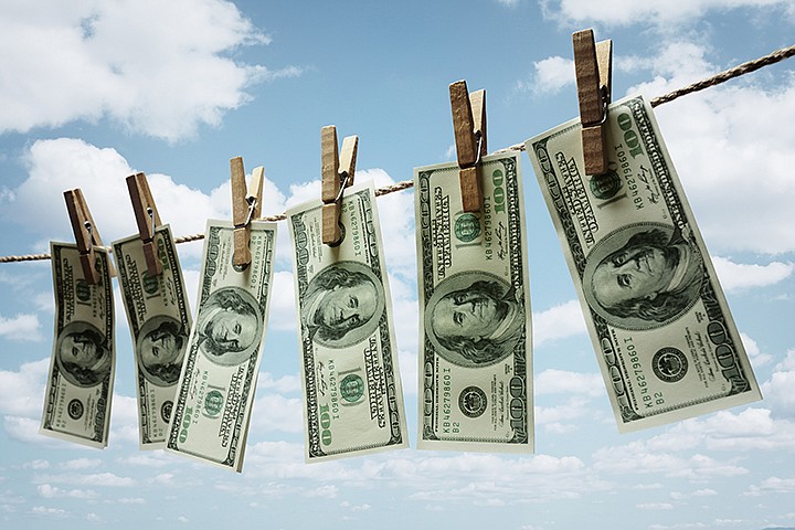 Hundred dollar bills hanging from a clothesline concept for money laundering, investment or venture capital funding