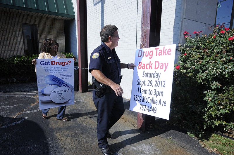 Gloria McClendon, left, Safety Committee Chair for the East Chattanooga Improvement, Inc., takes information posters outside with Chattanooga Police Lt. Brian Cotter, a volunteer, announcing a Drug Take Back Day in this file photo.