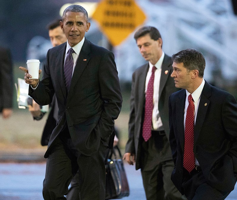 In this Nov. 29, 2016, file photo, President Barack Obama walks with his physician Dr. Ronny Jackson, right, towards a waiting Marine One as he leaves Walter Reed National Military Medical Center in Bethesda, Md., after visiting wounded service members. Now it's Washington's turn to examine Jackson. The doctor to Presidents George W. Bush, Barack Obama and now Donald Trump is an Iraq War veteran nominated to head the Department of Veterans Affairs. (AP Photo/Manuel Balce Ceneta, File)