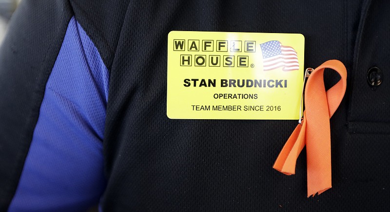 Waffle House employee Stan Brudnicki wears a ribbon on his uniform to honor shooting victims Wednesday, April 25, 2018, in Nashville, Tenn. 