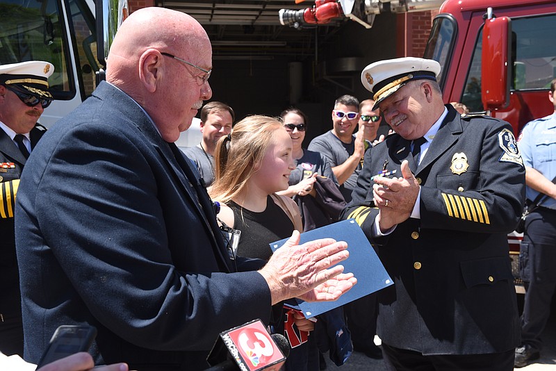 Serenity Russell, center, 12, is honored by Hamilton County EMS, and theChattanooga Fire Department for her efforts that prevented further harm to her mother who was involved in a serious traffic accident. Hamilton County EMS Deputy Chief John Combs, right, and HCEMS director Ken Wilkerson, left, give her a hand.