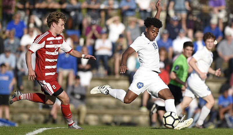 McCallie's Andre Roberts (19) fires a pass downfield as Baylor's Keegan Weekley (2) follows.   The Baylor Red Raiders visited the McCallie Blue Tornado in TSSAA soccer action on April 27, 2018