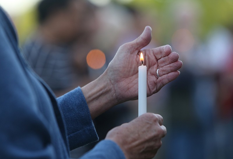 An attendee of the Vigil for Antioch held by Chattanooga Students Leading Change shields her candle from the breeze Sunday, April 29, 2018 at the Renaissance Park pavilion in Chattanooga, Tenn. The vigil was held to remember the four victims of the mass shooting at a Waffle House in Nashville, Tenn., a week ago.