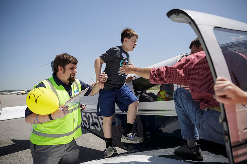 Byron Poe, left, helps Jackson Powers board an airplane for a flight during the Challenge Air Fly Day at the Chattanooga Airport's Wilson Air Center on Saturday, April 28, 2018, in Chattanooga, Tenn. Fly Day offers youth ages 7 to 21 with intellectual or physical disabilities and their families the chance to experience a 30-minute small-aircraft flight and to learn about aviation.