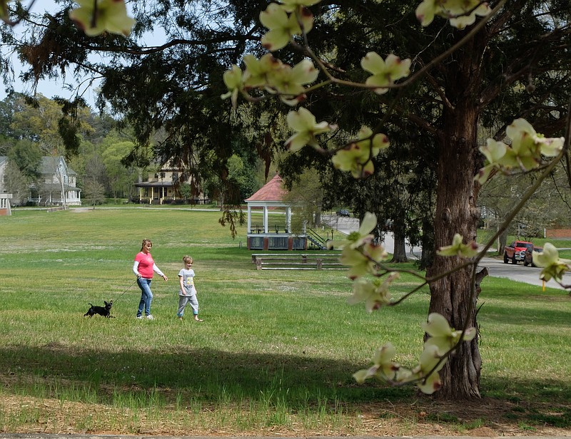 Pamela Harriod and her daughter, Destiny, walk their dog Black Jack on the Barnhardt Circle lawn near the bandstand on the historic grounds in Fort Oglethorpe. With the city working to build a dog park, the duo will soon have a new location for Black Jack to explore.