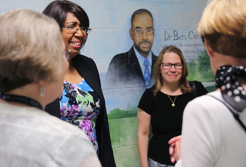 Candy Carson speaks with Lookout Valley Elementary School principal Alisan Taylor, the Carson Scholars Fund Director of Reading Rooms Tammy Blazenyak and Gale Hinton, the artist who crafted murals on the walls of the school, Monday, April 30, 2018 in front of one of Hinton's paintings of Dr. Ben Carson at Lookout Valley Elementary School in Chattanooga, Tenn. Carson was visiting the Ben Carson Reading Room which is in the library of the school.