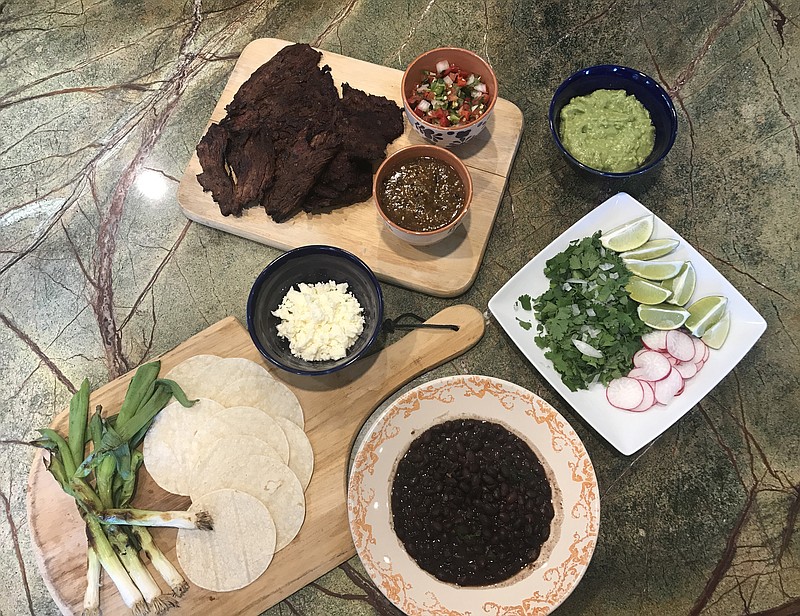 With Cinco de Mayo this weekend, we decided to make tacos featuring adobo-marinated skirt steak and a couple of sauces, including pico de gallo, salsa verde and a combination of avocado and salsa verde. We grilled the steak and the spring green onions and served with chopped onion, cilantro and sliced radishes, as well as black beans.