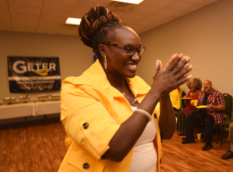 Katherlyn Geter claps her hands after hearing the first results coming in at Eastgate Town Center Tuesday night.
